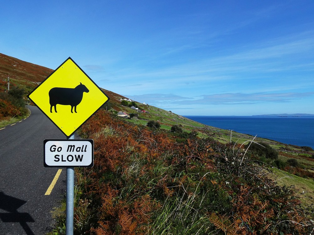 Panneau bilingue irlandais-anglais « Go Mall / Slow » dans la péninsule de Dingle (Kerry)